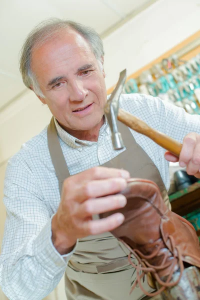Cobbler hammering an old shoe — Stock Photo, Image