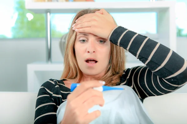 Woman shocked after reading thermometer — Stock Photo, Image