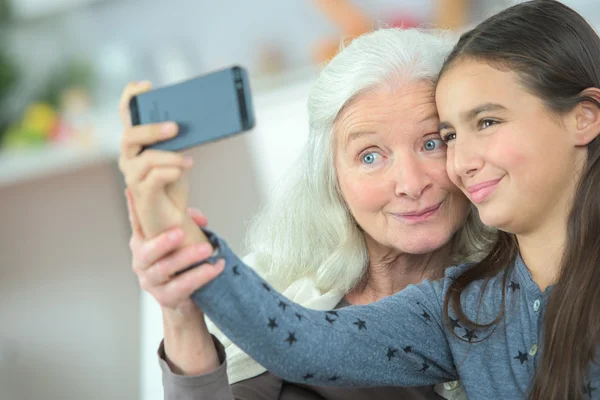 Liten flicka med en selfie med hennes mormor — Stockfoto