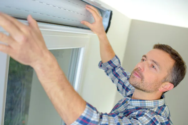 Handyman instalando um obturador de janela — Fotografia de Stock