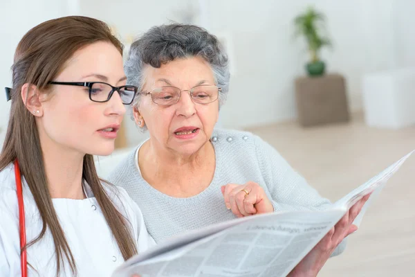 Médico ayudando a un paciente a leer — Foto de Stock