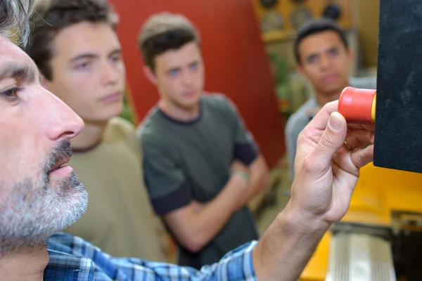 Tutor zeigt Schülern den Nothalt-Knopf am Gerät — Stockfoto
