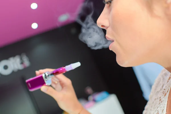 Woman puffing an e-cigarette — Stock Photo, Image