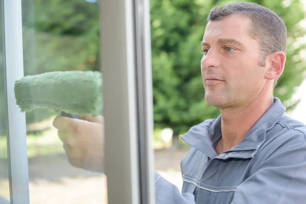 Hombre limpiando una ventana — Foto de Stock