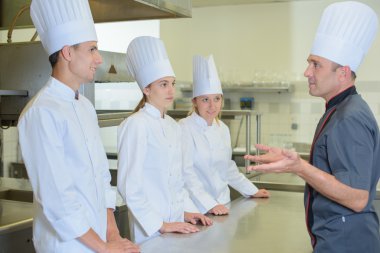 Chef addressing trainee cooks clipart