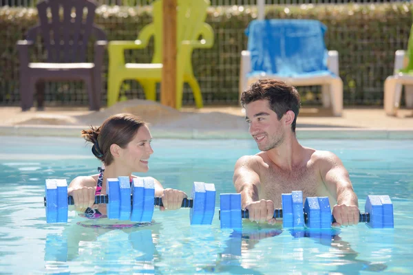 Mann und Frau halten Schwimmer in Schwimmbad — Stockfoto