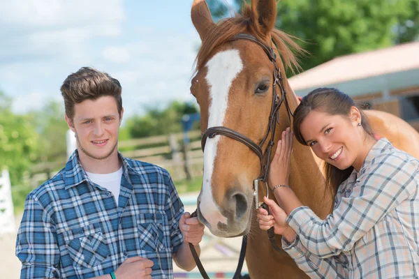 Adultos jóvenes con un caballo — Foto de Stock