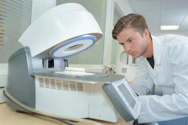 Mladý muž pomocí stroje v laboratoři — Stock fotografie