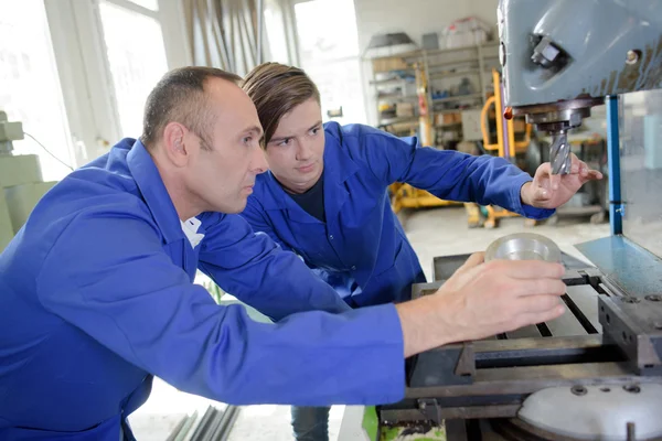 Due uomini che guardano trapano industriale — Foto Stock