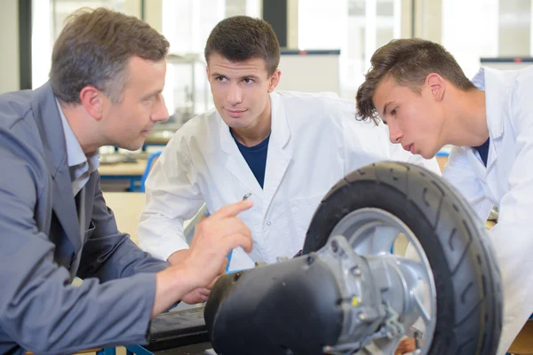 Engenheiro e estudantes olhando para a roda — Fotografia de Stock