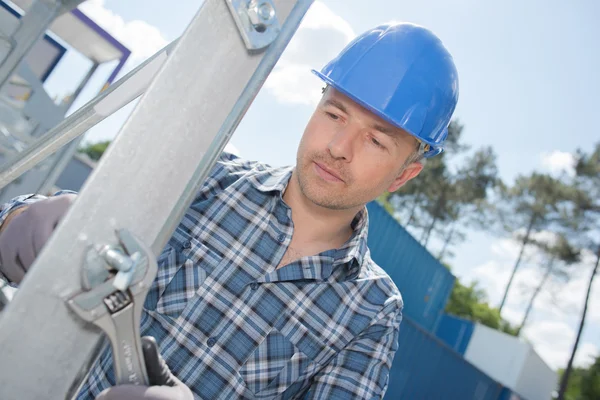 Workman dotažením šroubu na kovové konstrukci — Stock fotografie