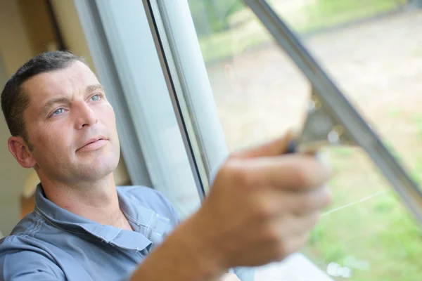 Hombre limpiando ventanas con escobilla — Foto de Stock