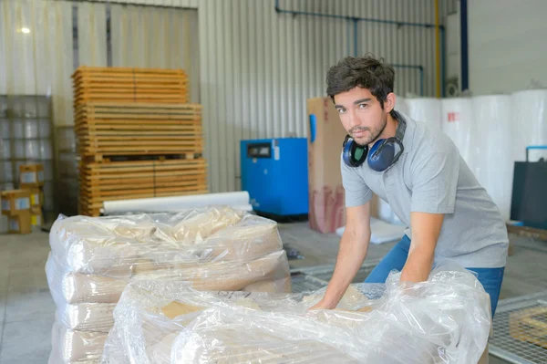 Trabajador manual recogiendo la bolsa de paleta — Foto de Stock