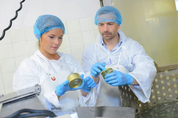 Factory workers checking tins — Stock Photo, Image