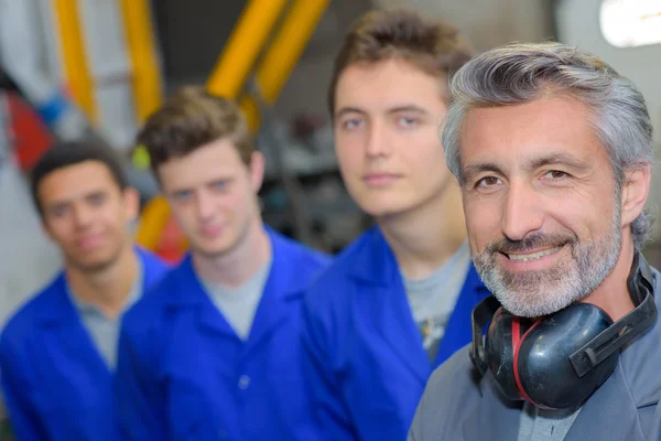 Tradesman with his three apprentices — Stock Photo, Image