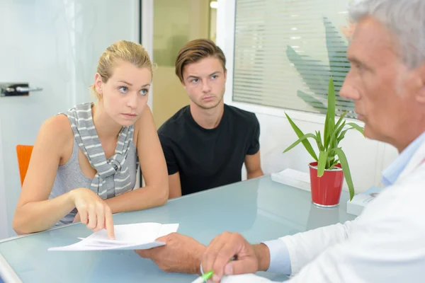 Jong paar in vergadering met arts — Stockfoto