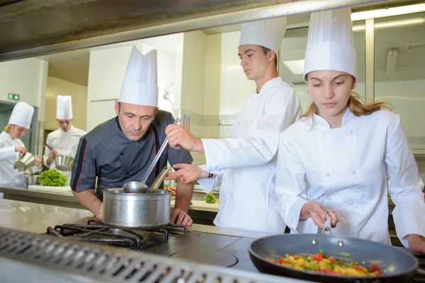 Chef observing trainee cooks — Stock Photo, Image
