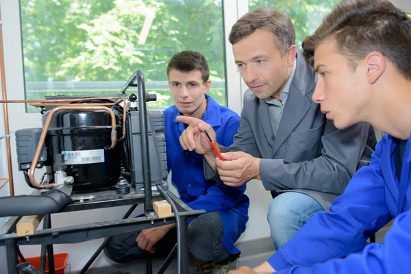 Man en studenten kijken naar een uitvinding — Stockfoto