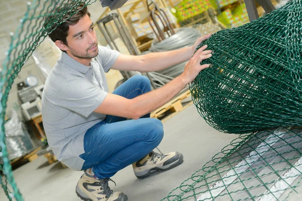 Homem desenrolando esgrima fio — Fotografia de Stock