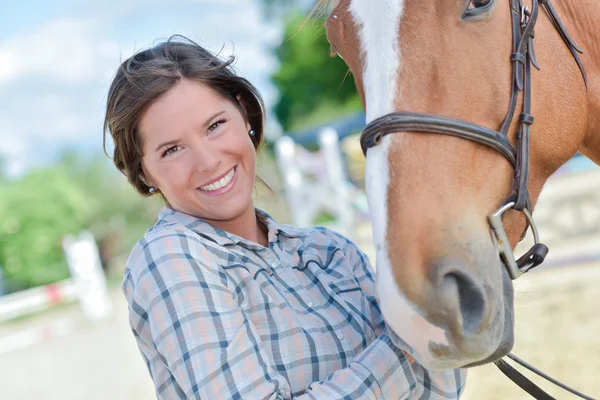 Kvinnan leende med en häst — Stockfoto