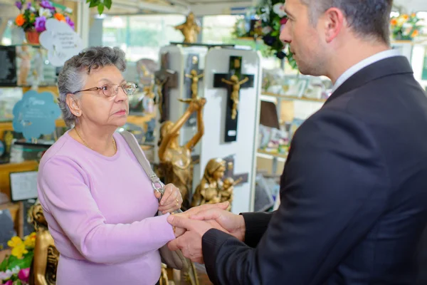 Mujer con enterrador entre artefactos conmemorativos — Foto de Stock