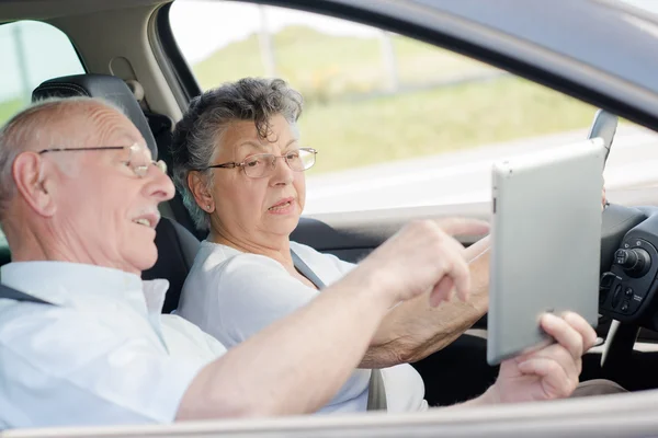 자동차, 운전 하는 여자, 태블릿의 화면을 보여주는 남자 노인 부부 — 스톡 사진