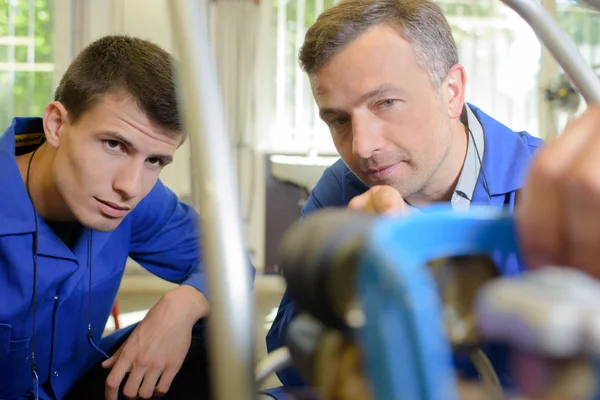 Technician showing gas bottle to apprentice — Stock Photo, Image