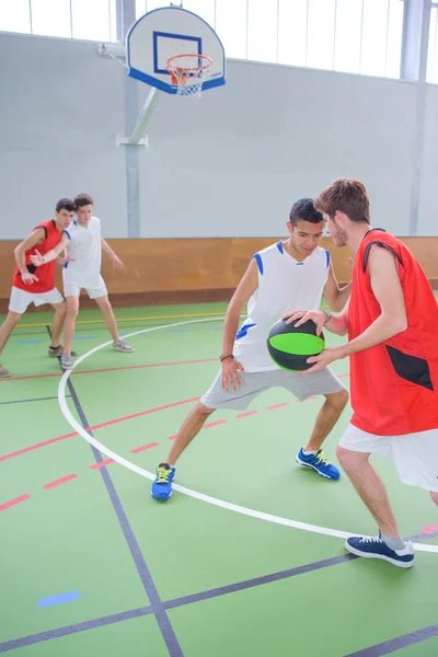 Mladí muži hrají basketbal — Stock fotografie