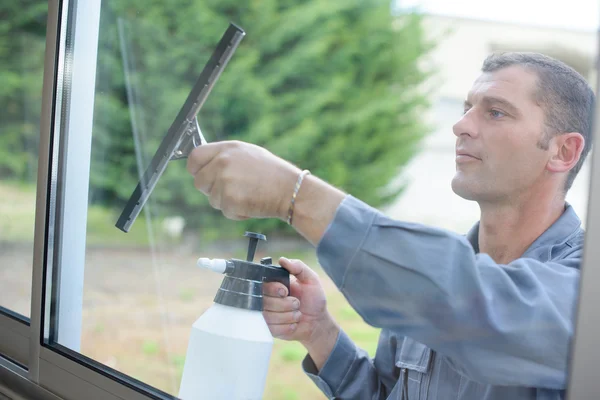 Hombre limpiando ventanas con escobilla — Foto de Stock