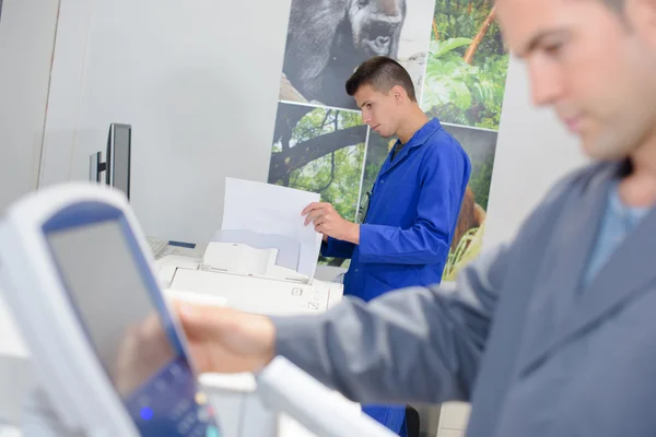 Mann gibt Informationen auf Steuerkissen ein — Stockfoto