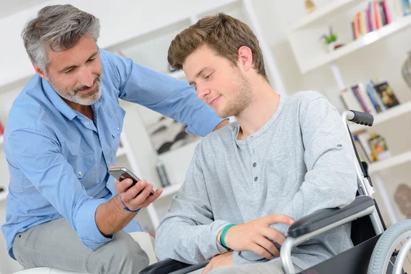 Uomo che mostra un messaggio a un giovane — Foto Stock