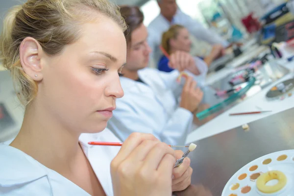 Técnico pintando prótesis dental — Foto de Stock