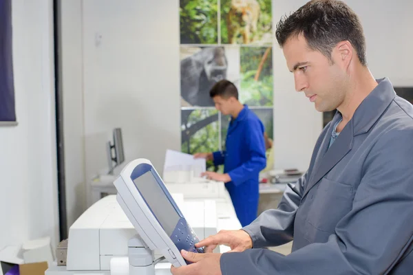 Uomo che utilizza il pad di controllo sulla stampante — Foto Stock