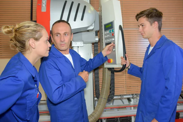 Mannelijke en vrouwelijke leerlingen vertoond machine — Stockfoto