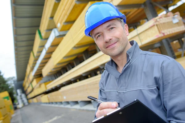 Hombre con portapapeles en el patio de constructores — Foto de Stock