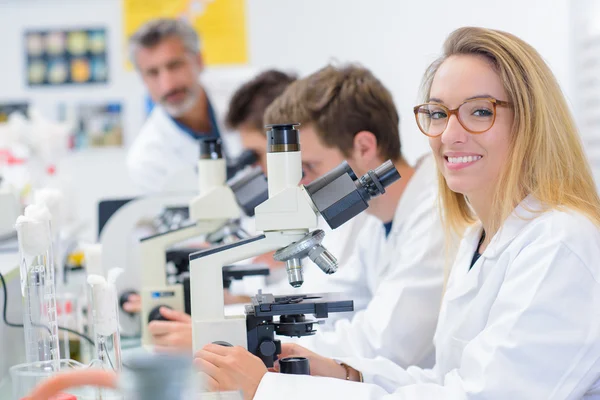 Señora mirando desde su microscopio, sonriendo —  Fotos de Stock