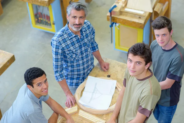 Apprentices and teacher looking upwards — Stock Photo, Image