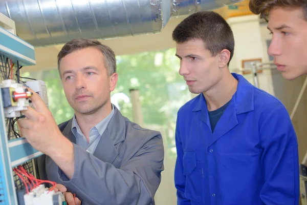 Les met een elektricien en twee leerlingen — Stockfoto