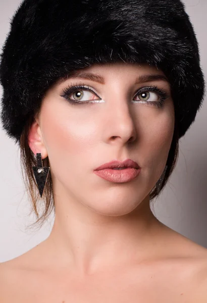 Attractive pensive young woman in a winter hat — Stock Photo, Image