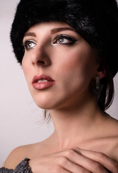 Pretty young woman daydreaming in a winter hat — Stock Photo, Image