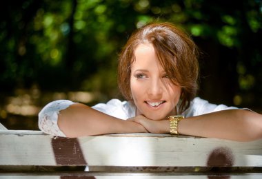 Bir ahşap Bank eğilerek mutlu düşünceli kadın