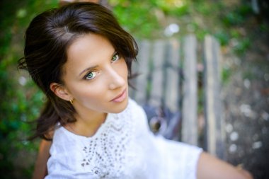 Kadın kameraya yüksek açıdan bakarak bir bankta