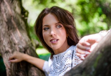 Düşünceli kadın ağaç gövdesi karşı yaslanmış