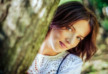 Güzel kadın bir ağacın arkasından bakmak