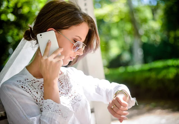 Woman with Cell Phone Looking Down at Watch — Stock Photo, Image