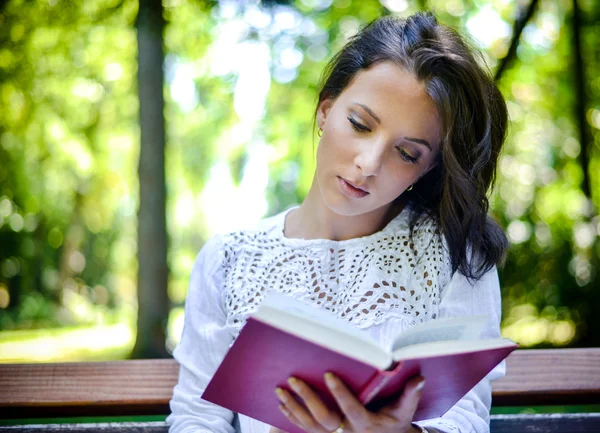 Frau liest Buch im Freien in friedlichem Wald — Stockfoto