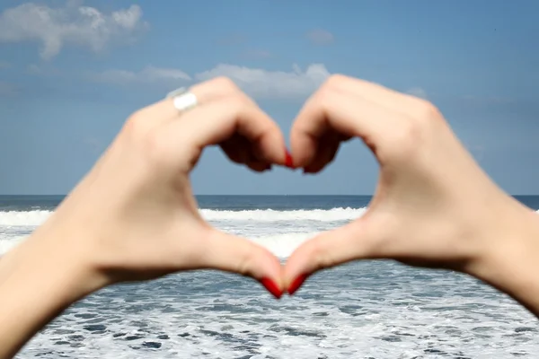 Mano femenina haciendo una forma de corazón — Foto de Stock