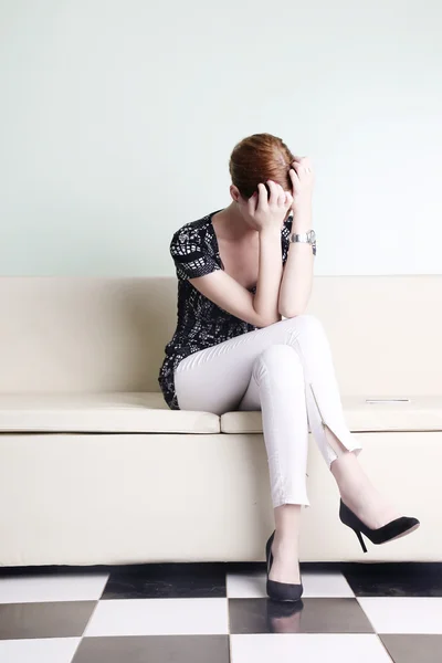 Ung kvinna sitter med händerna över hennes ansikte, uttråkad, orolig eller stressad — Stockfoto