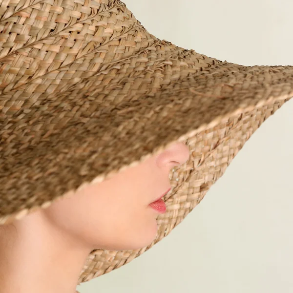 Side view of young woman with big straw hat Stock Image