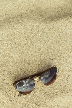 Plajda güneş gözlüklü kum arka plan